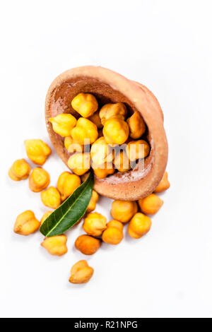 Raw bright dark brown colored Desi chana or original chickpea in a glass bowl isolated on white. Stock Photo