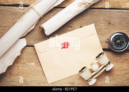 Old feather, envelope, telescope and compass on the wooden table Stock Photo