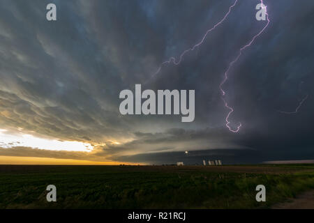 Lightning in a supercell thunderstorm over northeastern Colorado at sunset, wallcloud with beautiful mothership appearance. Stock Photo