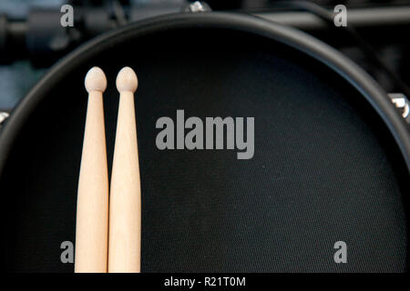 Looking down on a black electronic drum with two sticks ready to be played Stock Photo