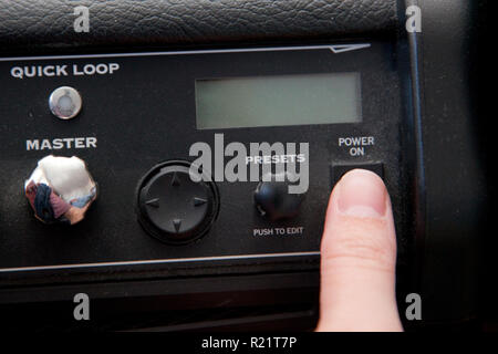 Turning the power switch on a dusty guitar amplifie ready to be played Stock Photo