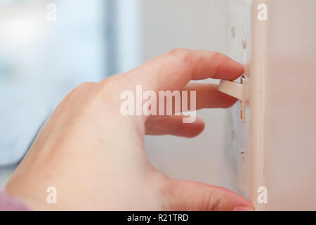 Hand flips a light switch with copy space Stock Photo