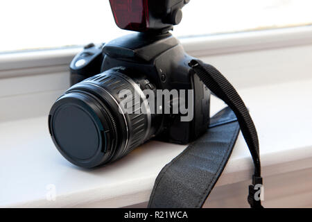 A digital single lens reflex camera sits in the window ready for use Stock Photo