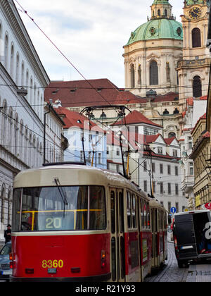Prague, Czech Republic - October 31, 2018 Public transport Tram number 20 runs through Karmelitska street with the Saint Nicholas Bell Tower in the ba