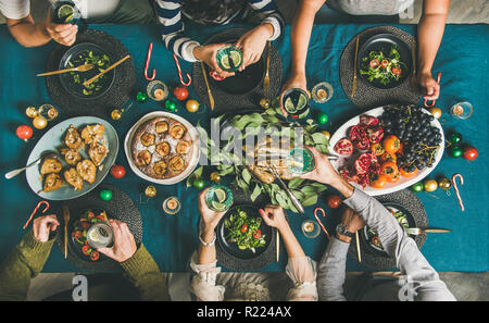 Human hands holding glasses with drinks at Christmas party dinner Stock Photo