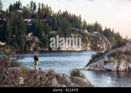 A man flies his drone over the ocean at Whytecliff Park., West Vancouver. Stock Photo