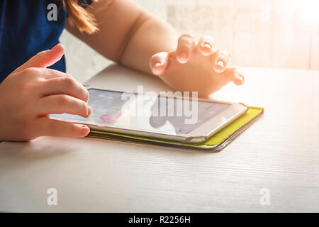Woman using a tablet in a room illuminated by sunlight Stock Photo