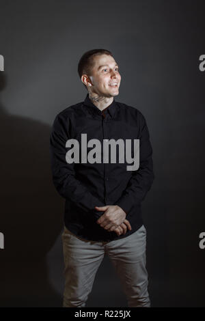 Portrait of determined goodlooking man wearing black shirt, black background. Stock Photo