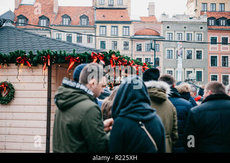 Warsaw, December 25, 2017: People choose Christmas gifts or fast food at the traditional decorated Christmas market. Selective focus. Stock Photo