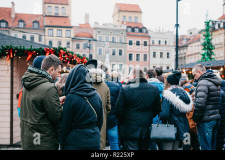 Warsaw, December 25, 2017: People choose Christmas gifts or fast food at the traditional decorated Christmas market. Stock Photo
