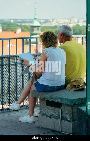 Couple reading touristic map information in the Old Town of Warsaw in Poland Stock Photo