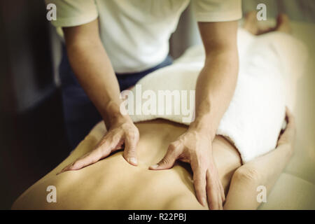 Physiotherapist giving back massage to a woman Stock Photo