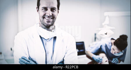 Dentist standing with arms crossed in clinic Stock Photo