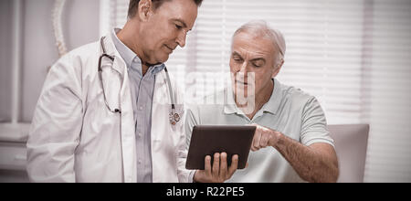 Doctor and senior patient using digital tablet Stock Photo