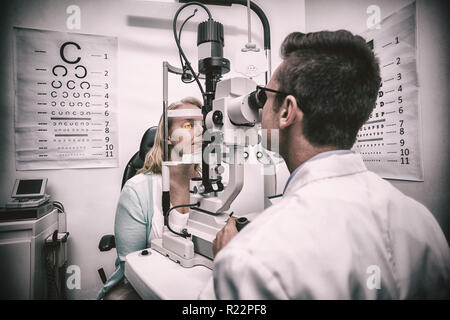 Optometrist examining female patient on slit lamp Stock Photo