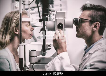 Optometrist examining female patient on slit lamp Stock Photo