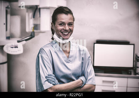 Smiling dental assistant standing with arms crossed Stock Photo