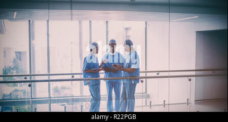 Team of surgeons discussing over digital tablet Stock Photo