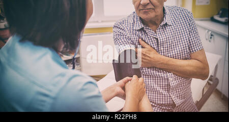 Female doctor checking blood pressure of patient Stock Photo