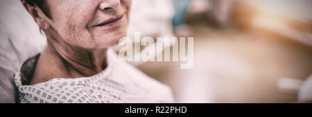 Portrait of smiling patient sitting on bed Stock Photo