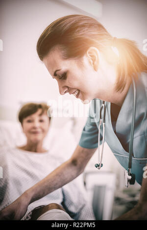 Nurse bandaging leg of patient Stock Photo