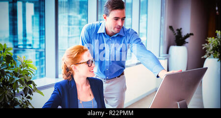 Executives having discussion over personal computer at desk Stock Photo