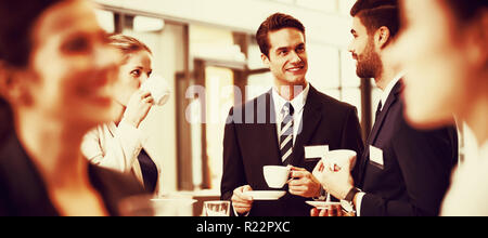 Businesspeople interacting with each other while having coffee Stock Photo