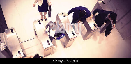 Business executives passing through turnstile gate Stock Photo