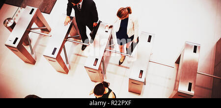 Business executives passing through turnstile gate Stock Photo