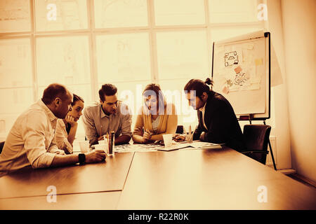 Serious photo editors discussing about photos on table Stock Photo