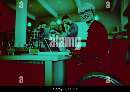 Happy disabled businesswoman using laptop at desk Stock Photo