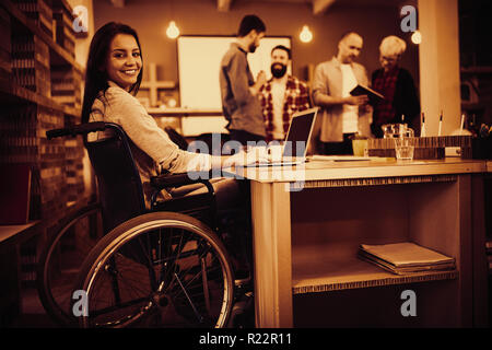 Confident disabled businesswoman using laptop in office Stock Photo