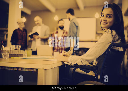 Confident disabled businesswoman writing at desk Stock Photo