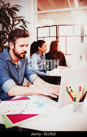 Creative business people using technologies at desk Stock Photo
