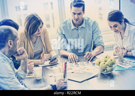 Editors with documents working in meeting room Stock Photo