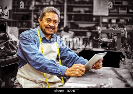 Portrait of shoemaker using digital tablet Stock Photo