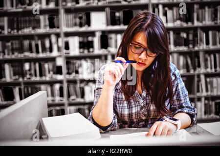 Female student looking at notes in library Stock Photo