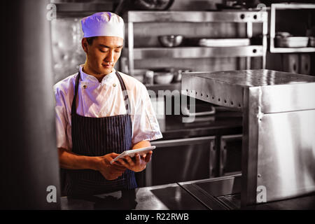 Chef using digital tablet in the commercial kitchen Stock Photo