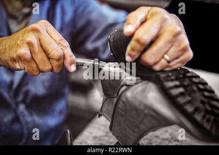 Shoemaker repairing a shoe sole Stock Photo