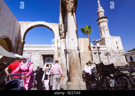 Damascus, Syria : People walk under the ruins of the Roman Jupiter Temple at the entrance of Al-Hamidiyah Souq, built between the 1st century BCE and  Stock Photo