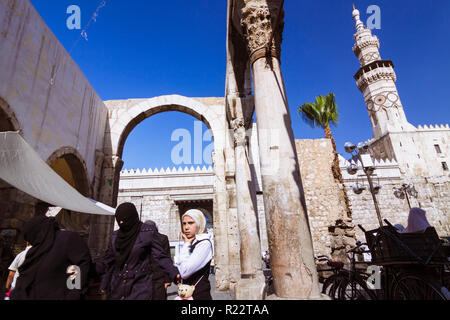 Damascus, Syria : People walk under the ruins of the Roman Jupiter Temple at the entrance of Al-Hamidiyah Souq, built between the 1st century BCE and  Stock Photo