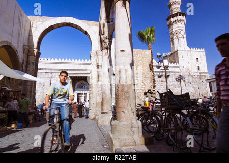 Damascus, Syria : People walk under the ruins of the Roman Jupiter Temple at the entrance of Al-Hamidiyah Souq, built between the 1st century BCE and  Stock Photo