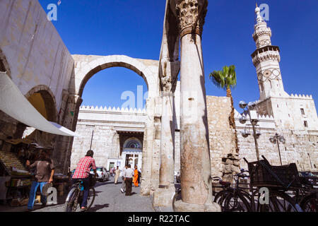 Damascus, Syria : People walk under the ruins of the Roman Jupiter Temple at the entrance of Al-Hamidiyah Souq, built between the 1st century BCE and  Stock Photo