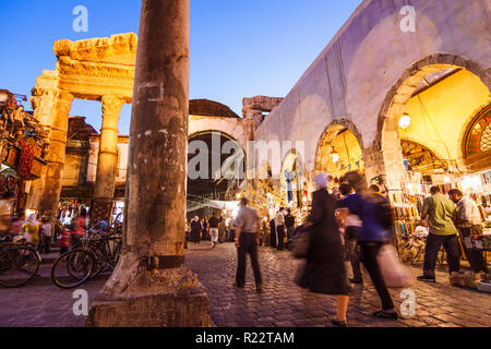 Damascus, Syria : Passersby at the ruins of the Roman Jupiter Temple (1st century BCE to 4th century CE) at the entrance of Al-Hamidiyah Souq. Stock Photo