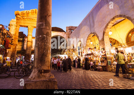 Damascus, Syria : Passersby at the ruins of the Roman Jupiter Temple (1st century BCE to 4th century CE) at the entrance of Al-Hamidiyah Souq. Stock Photo