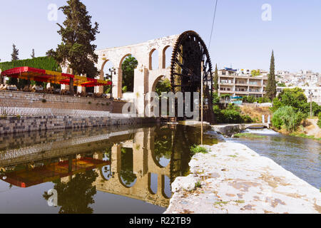 Hama, Hama Governorate, Syria : 14th century al-Muhammadiyah noria on the Orontes river, the larget of the Hama water wheels and its old aqueduct whic Stock Photo