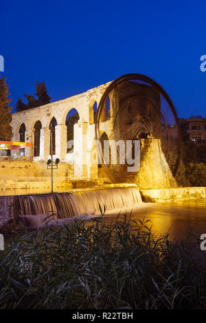 Hama, Hama Governorate, Syria : 14th century al-Muhammadiyah noria on the Orontes river at night, the larget of the Hama water wheels and its old aque Stock Photo