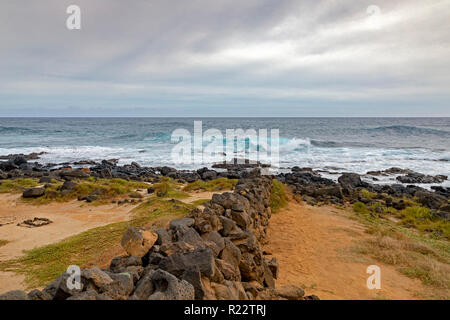 Ka Lae, Hawaii - A stone wall leads to the Pacific Ocean at the southernmost point in the United States, also called South Point, on Hawaii's Big Isla Stock Photo