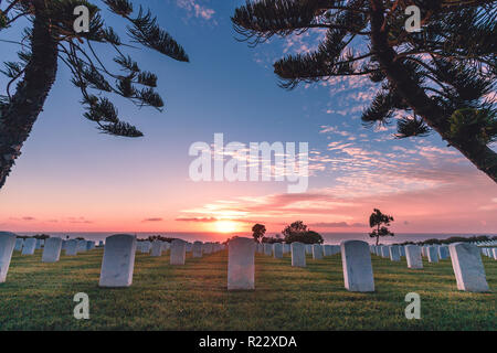 Fort Rosecrans National Cemetery, Point Loma, San Diego, California, USA.  Monument headstones along the coast during a pink, orange, and blue sunset  Stock Photo