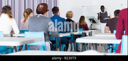 Multinational group of adult students working together with professor in auditorium Stock Photo